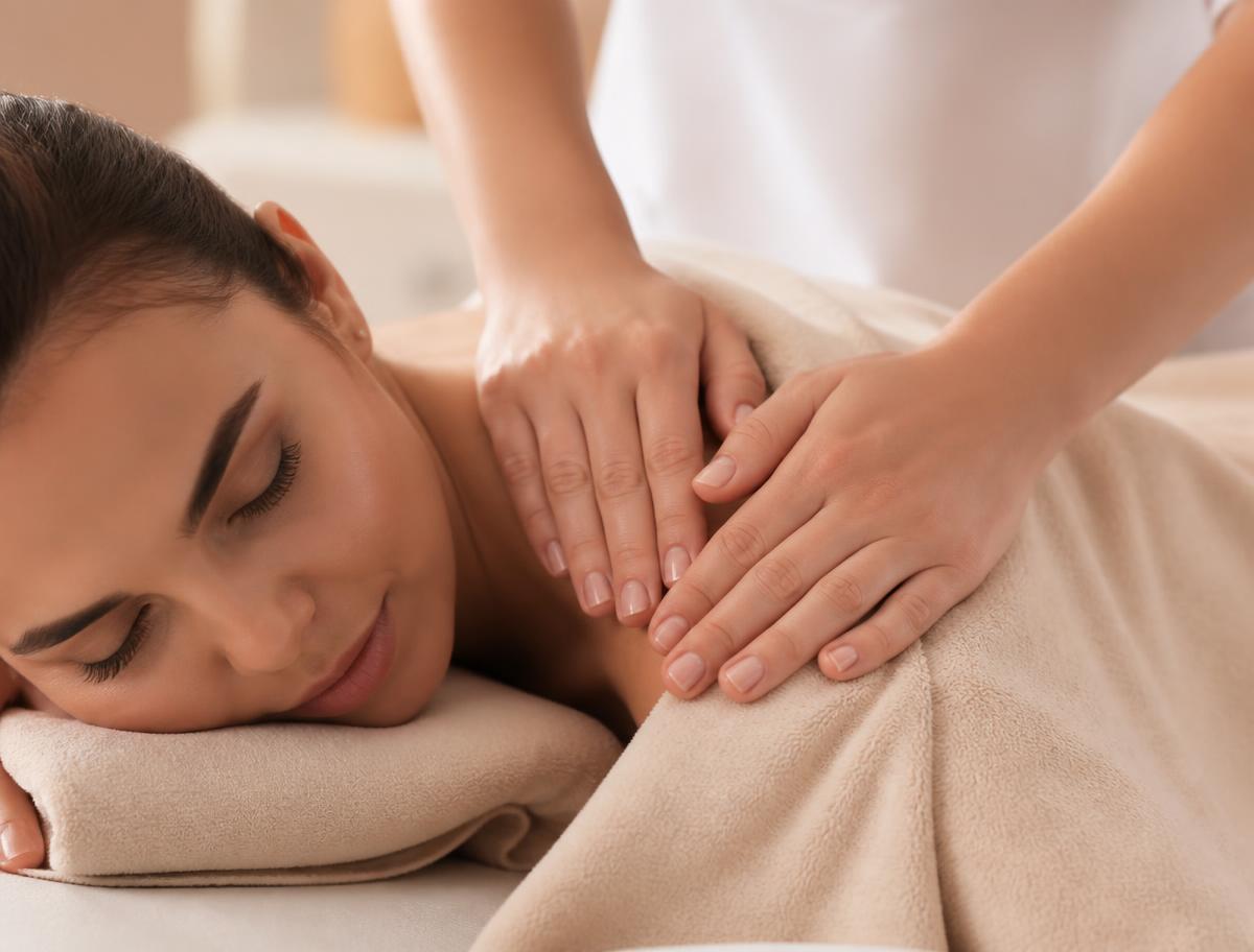 Therapist's hands during a relaxing massage under warm towels